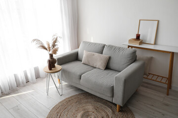 Interior of modern living room with sofa and table near window