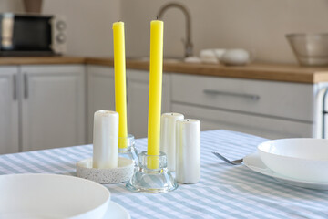 Simple table setting with candles in kitchen