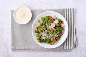 Green pasta with peas, sausages and cheese