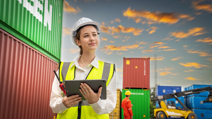 Woman foreman smile at Cargo Ship yard warehouse , Manager use tablet in white helmet Safety Supervisor in Container Custom Terminal port concept import export