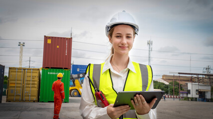 Fototapeta na wymiar Woman foreman smile at Cargo Ship yard warehouse , Manager use tablet in white helmet Safety Supervisor in Container Custom Terminal port concept import export