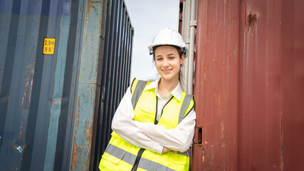 Woman foreman smile at side of Cargo container in warehouse , Manager in white helmet Safety Supervisor in Container Custom Terminal port concept import export