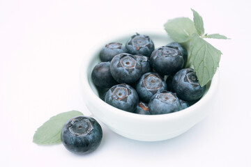 Blueberries in a bowl with a mint leaf