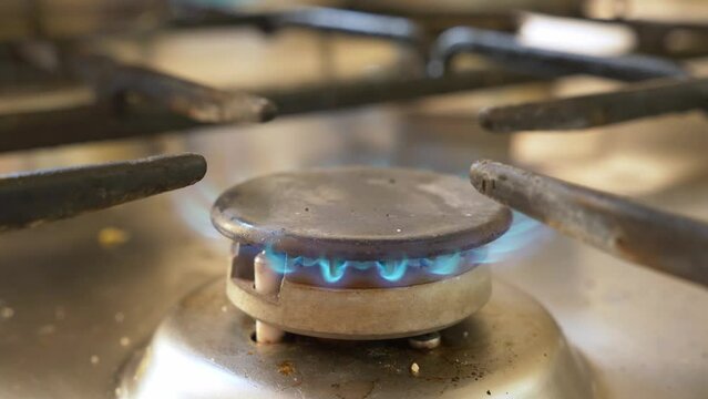 Close-up shot of lightning gas cooking stove, producing a blue flame.