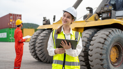 Obraz na płótnie Canvas Woman foreman control forklift loading Containers cargo from Truck to port in warehouse , Manager use tablet in white helmet Safety Supervisor in Container Custom Terminal port concept import export