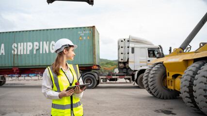 Woman foreman control forklift loading Containers cargo from Truck to port in warehouse , Manager use tablet in white helmet Safety Supervisor in Container Custom Terminal port concept import export