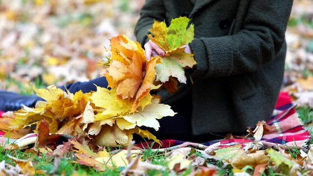 woman making wreath from the yellow maple leaves