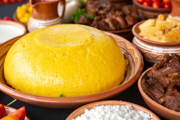 Homemade Romanian Food with polenta, meat, cheese and vegetables. Delicious corn porridge in clay dishes. Mamaliga or polenta, a traditional dish in Moldova, Hungary and Ukrainian cuisine.
