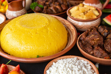 Homemade Romanian Food with polenta, meat, cheese and vegetables. Delicious corn porridge in clay dishes. Mamaliga or polenta, a traditional dish in Moldova, Hungary and Ukrainian cuisine.
