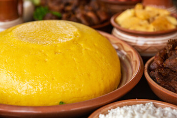 Homemade Romanian Food with polenta, meat, cheese and vegetables. Delicious corn porridge in clay dishes. Mamaliga or polenta, a traditional dish in Moldova, Hungary and Ukrainian cuisine.

