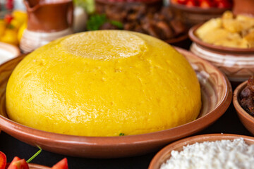 Homemade Romanian Food with polenta, meat, cheese and vegetables. Delicious corn porridge in clay dishes. Mamaliga or polenta, a traditional dish in Moldova, Hungary and Ukrainian cuisine.
