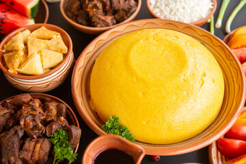 Homemade Romanian Food with polenta, meat, cheese and vegetables. Delicious corn porridge in clay dishes. Mamaliga or polenta, a traditional dish in Moldova, Hungary and Ukrainian cuisine.
