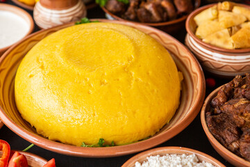 Homemade Romanian Food with polenta, meat, cheese and vegetables. Delicious corn porridge in clay dishes. Mamaliga or polenta, a traditional dish in Moldova, Hungary and Ukrainian cuisine.
