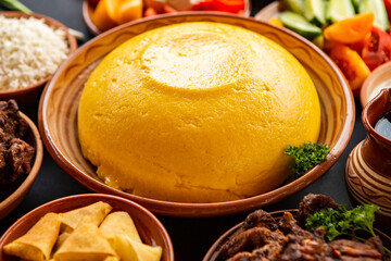 Homemade Romanian Food with polenta, meat, cheese and vegetables. Delicious corn porridge in clay dishes. Mamaliga or polenta, a traditional dish in Moldova, Hungary and Ukrainian cuisine.
