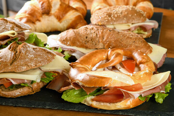 Delicious sandwiches with prosciutto and cheese served on table