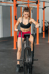 Sportswoman exercising on air bike