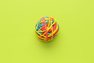 Colorful rubber band ball on green background