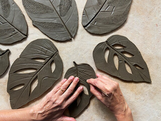 Terracotta artist's hands working on clay art work.
