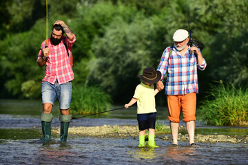 Fishing with son and grandson. Grandfather and father with cute child boy are fishing.