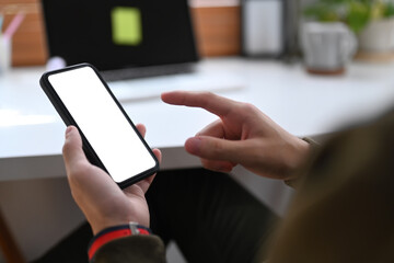 Close up view man sitting in his home office and using mobile phone. White screen for your advertise text