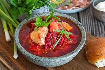 National dish of Ukrainian cuisine borscht with vegetables, turkey meat, herbs, sour cream and traditional bread (bun with garlic and dill, pampushka) with bacon (pork). Cultural heritage.
