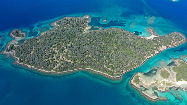 Aerial drone photo of tropical exotic volcanic island complex of Lihadonisia  forming a blue lagoon and small islet of Monolia with turquoise clear organised beach, north Evia island, Greece