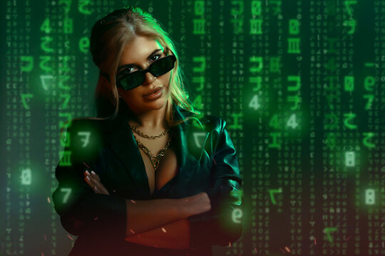 Gorgeous woman in matrix style suit. Black leather and reflection of code in glasses in green light and shadows of the matrix. Cyber technology concept, future and progress