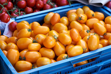 Orange and red tomatos in a crate at the farmers market