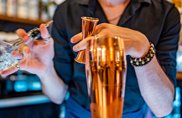man bartender hand making negroni cocktail in bar