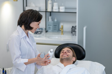 Obraz premium Female cosmetologist woring with the male customer in the beauty salon