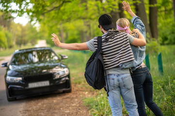 Young people in the forest stopping the car and looking joyful