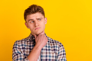 Obraz premium Photo of young man hand touch chin thoughtful ponder look empty space isolated over yellow color background
