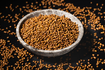 A buckwheat tea in a bowl on dark background.