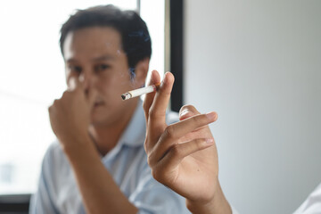 passive smoking effect, person cover his nose and avoid smoker near him - obrazy, fototapety, plakaty