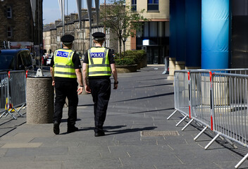 Police officer on duty on a city centre street during special event. 