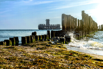 Old ruined wooden pier and a sandy beach