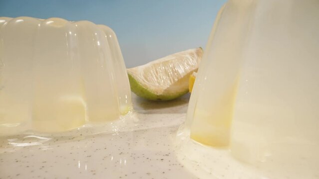 Lemon jelly on a plate with lemon slices. The sun and the blue sky. Dolly slider extreme close-up.
