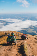 people riding suv cars at the mountain peak