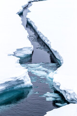 A crack in the ice. The ice shelf opens up as an icebreaker ship passes through. Svalbard, a Norwegian archipelago between mainland Norway and the North Pole and in the arctic circle