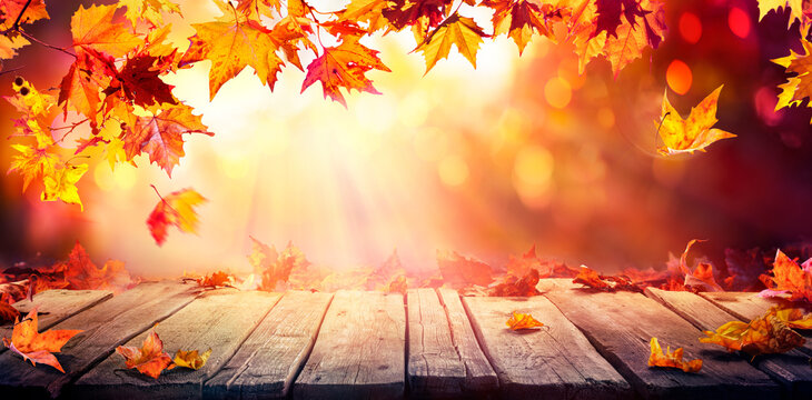 Autumn - Wooden Table With Orange Leaves  At Sunset In Defocused Abstract Background