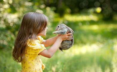 a depersonalized girl holding a small rabbit in her arms