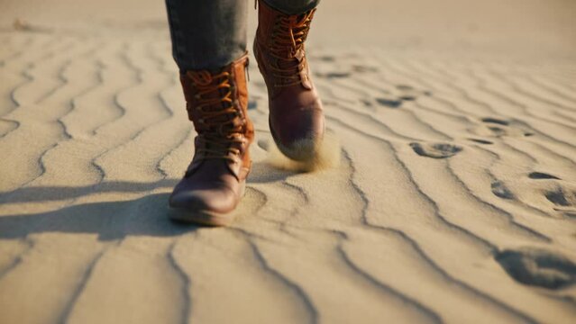 Feet in shoes walking on the sand, close-up 6k
