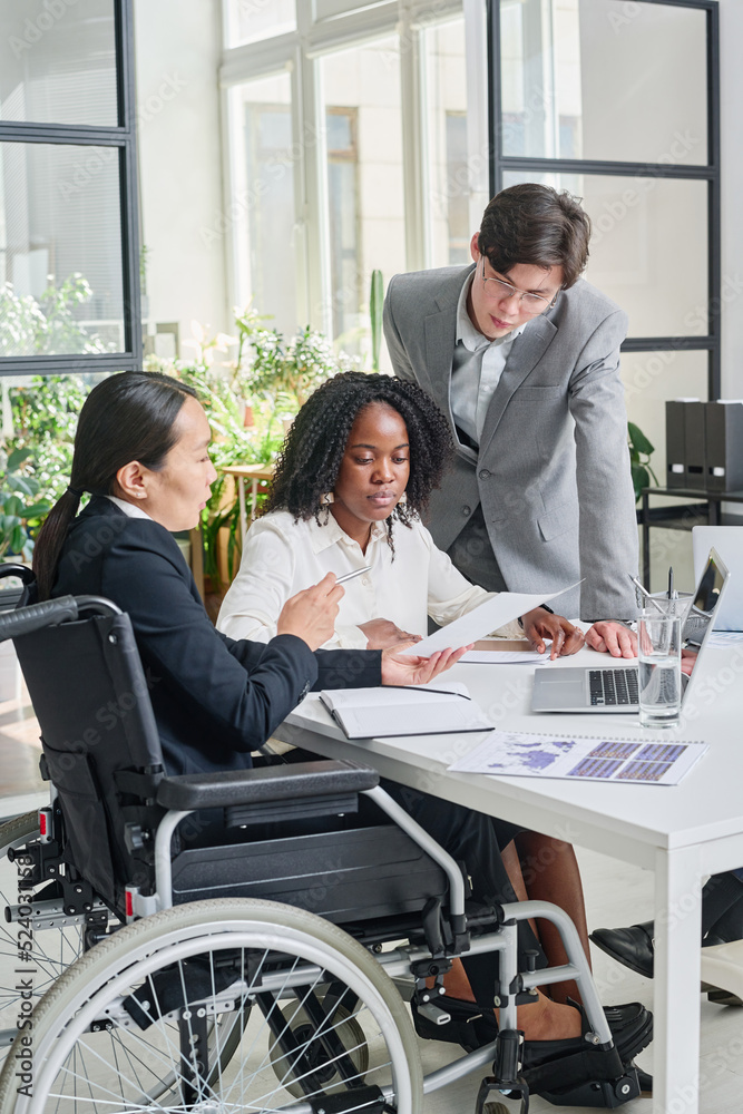 Wall mural asian businesswoman with disability working with her colleagues at meeting at office