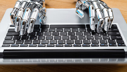Robot hand typing on laptop
