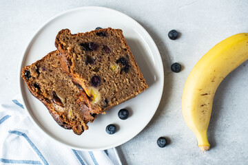 Sliced banana bread with blueberries on a plate. Top view.