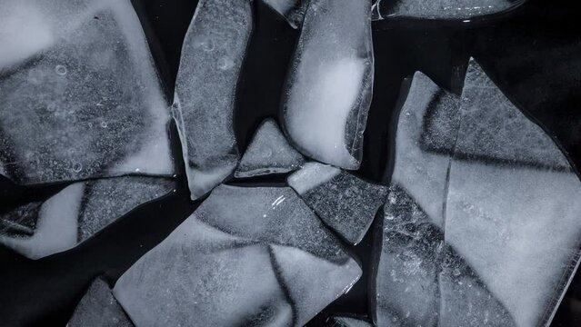 Time lapse of melting ice on black background
