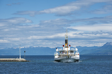 vintage steamboat arriving at a pier on Lake Geneva in Nyon, switzerland