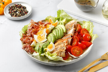 Cobb salad with bacon, avocado, tomato, grilled chicken, eggs isolated on  white background. American salad. Healthy food.