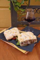 Knusprig gegrilltes Spanferkel-Sandwich mit einem Glas Rotwein