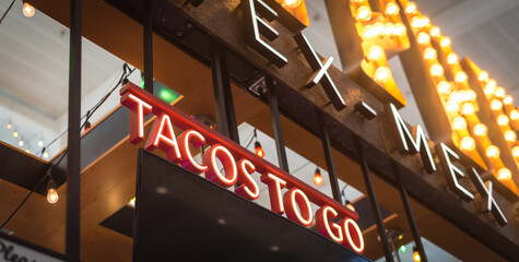 Panorama view Tex Mex restaurant welcome sign with LED Tacos to go text in Texas, America
